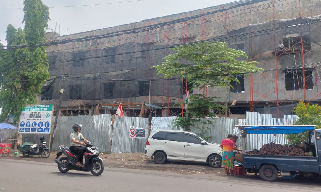 TERANCAM MANGKRAK: Pengendara motor melintas di depan Gedung Inspektorat Kota Probolinggo, yang masih dalam proses pembangunan.