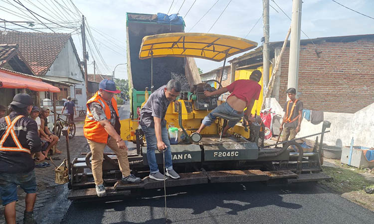 SUPAYA MAKIN NYAMAN: Pekerja menyelesaikan pekerjaan fisik pemeliharaan berkala jalan dengan hotmix di ruas Pagak - Kedungboto, Kecamatan Beji.