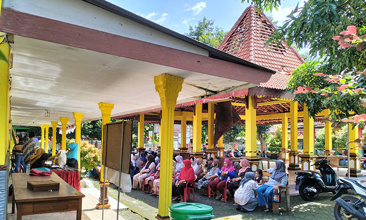 NGEMPER: Sejumlah warga terpaksa harus ngemper di pelataran Balai Desa Tunggulwulung, Kecamatan Pandaan, usai pendopo desa tak bisa difungsikan.