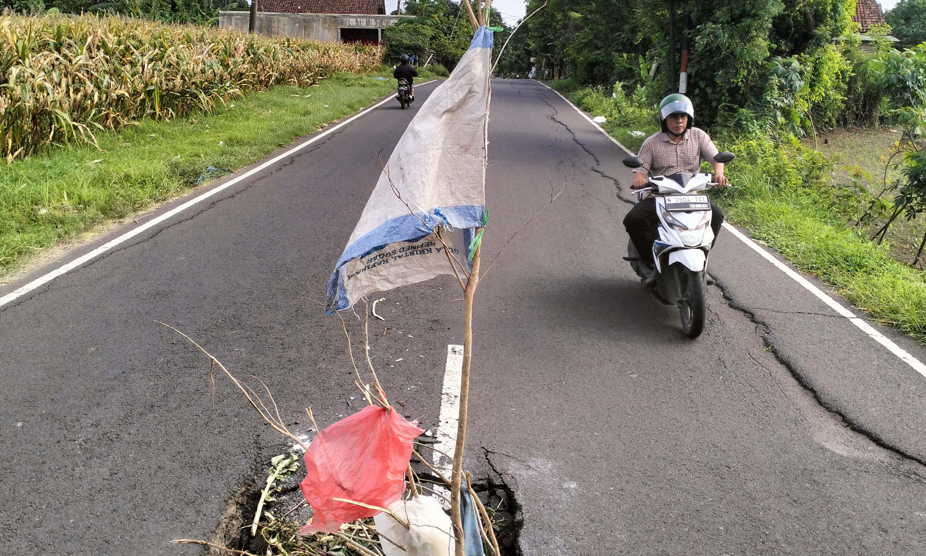 DITANDAI: Jalan di Dusun Doyong, Desa Kenduruan, Kecamatan Sukorejo yang ambles. Untuk menghindari petaka, jalan setempat dikasih tanda oleh warga. Mereka berharap, segera ada perbaikan.