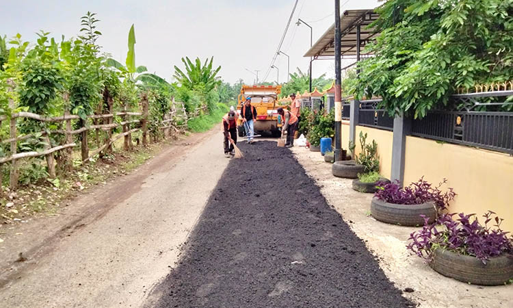 SUDAH MULUS: Pekerja dengan truk alpomain milik Dinas PUPR Pekerjaan Umum dan Penataan Ruang saat membenahi ruas Tambakrejo - Lumbang beberapa waktu lalu.