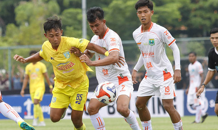 HASIL MANIS: Pemain Gresik United (kostum kuning) dikawal pemain Persekabpas dalam laga di Lapangan Thor, Senin (1/12) sore. Persekabpas mampu menang tipis dalam laga yang berkesudahan dengan skor 2-1