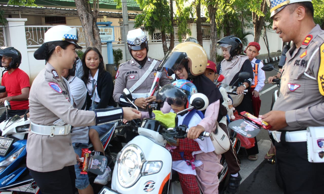 HUMANIS: Satlantas Polres Probolinggo Kota melakukan sosialisasi dan bagi-bagi helm di Simpang Empat Brak, Rabu (26/11).