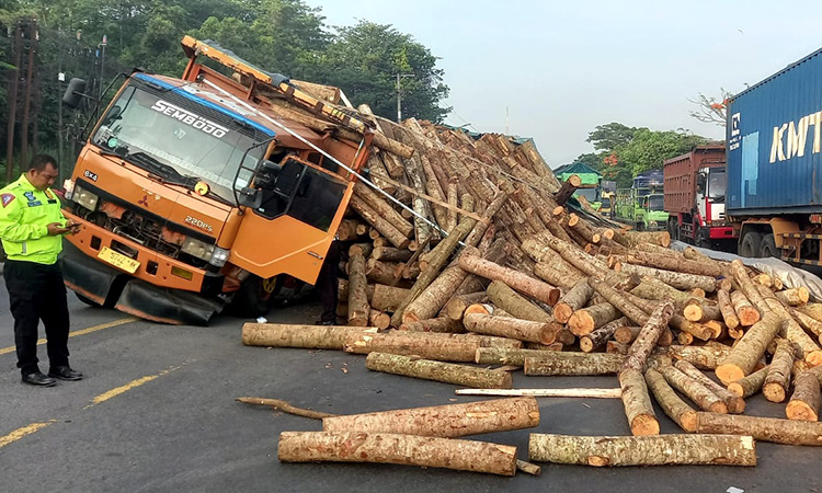 GANGGU LALU LINTAS: Kondisi truk muat kayu usai muatannya tumpah ke jalan raya Raci, Bangil, (2/12)