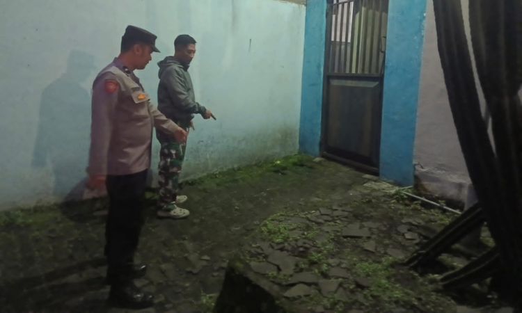 TUNJUKKAN: Petugas saat menunjukkan tempat motor korban terparkir. Terduga pelaku merusak gembok pagar dan menggondol motor korban.