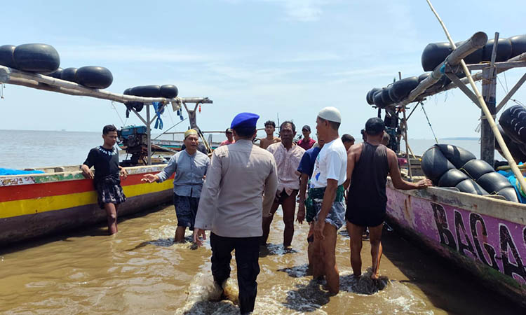 BERI IMBAUAN: Anggota Satpolairud Polres Pasuruan Kota saat menyapa nelayan. Petugas memberikan imbauan, agar nelayan tetap waspada saat melaut.