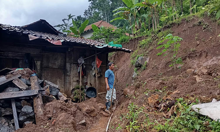 BELUM DIBERSIHKAN: Material longsor yang mengenai rumah warga di Desa Andungbiru, Tiris, Rabu (3/12). Ada dua titik longsor yang terjadi setelah hujan mengguyur sejak siang sampai sore.