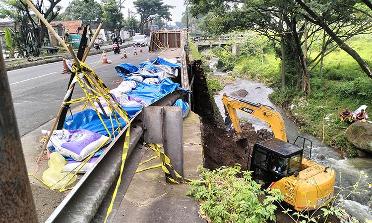 DIKERAHKAN: Alat berat yang dikerahkan untuk mengerjakan TPT di ruas Malang - Surabaya, Desa Parerejo, Kecamatan Purwodadi. Perbaikan ditargetkan rampung, dalam dua pekan.