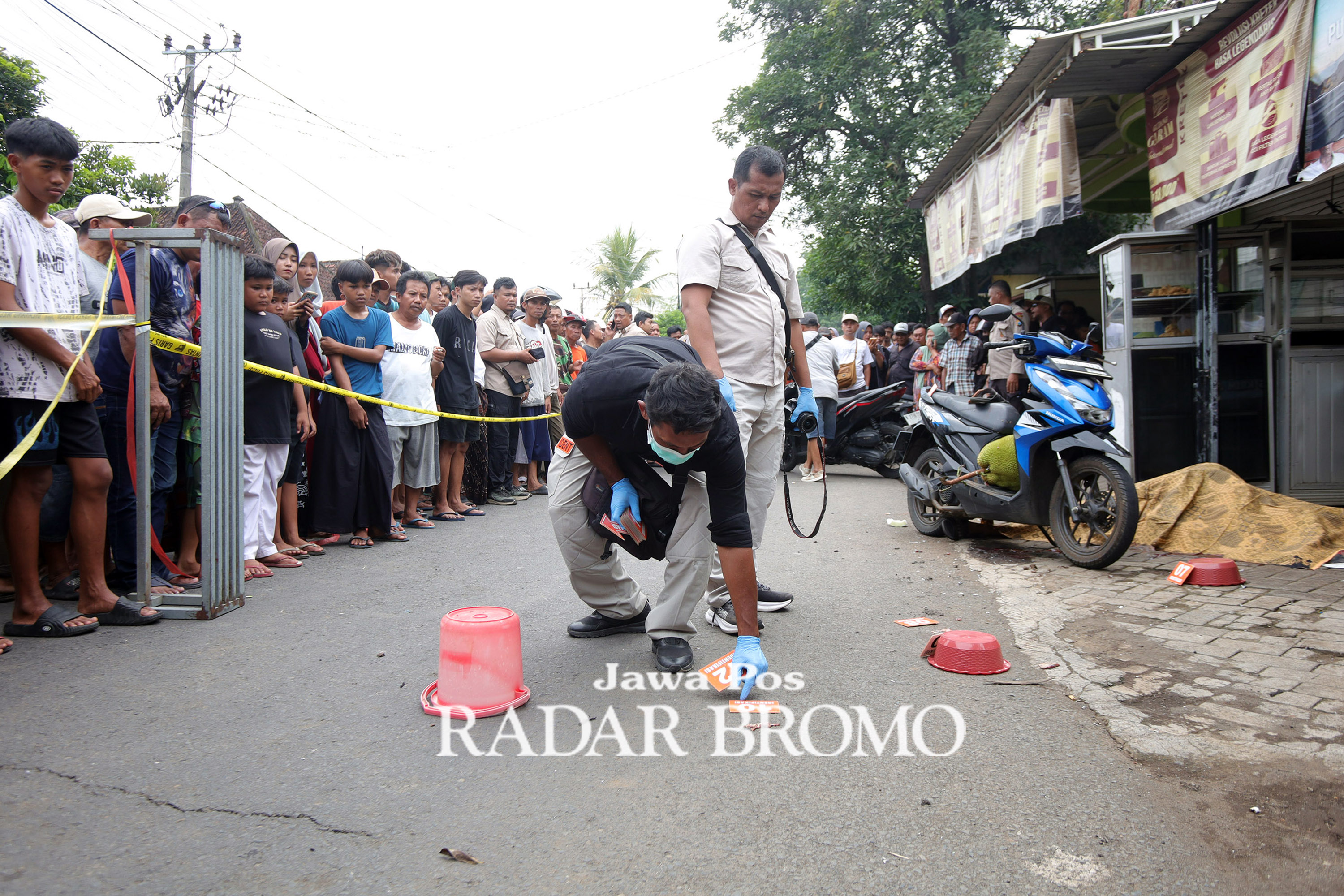 JADI TONTONAN WARGA: Tim identifikasi Satreskrim Polres Pasuruan saat melakukan olah TKP pemotor tewas dibondet di Sukorejo, Pasuruan (4/12).