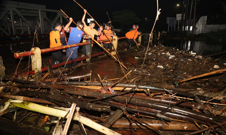 Petugas saat mengevakuasi tumpukan sampah kiriman banjir yang tersangkut di Bok Wedi Blandongan, Pasuruan.