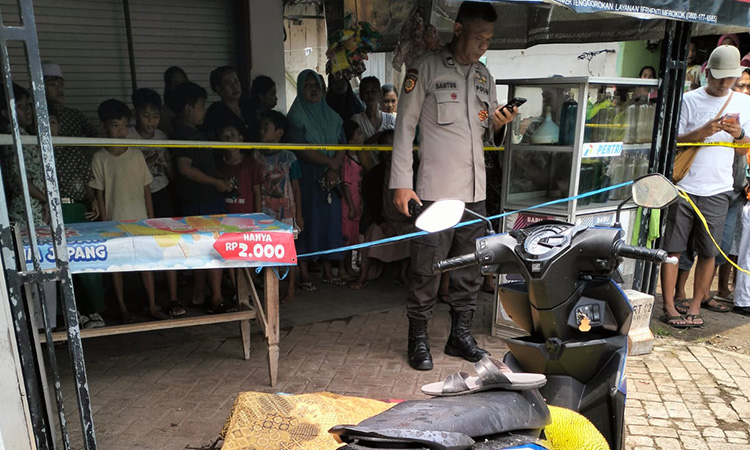PASANG POLICE LINE: Anggota kepolisian memasang police line di lokasi korban tewas dibondet orang tak dikenal, Kamis siang (4/12)