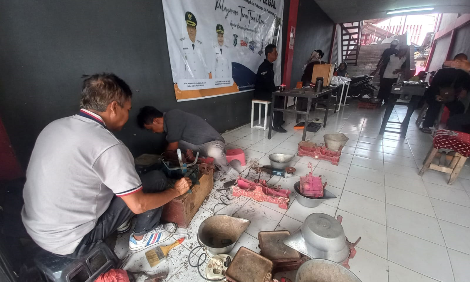 REPARASI: Petugas DKUP Kota Probolinggo mereparasi timbangan yang tak lolos uji tera di Pasar Gotong Royong, Kamis (4/12).