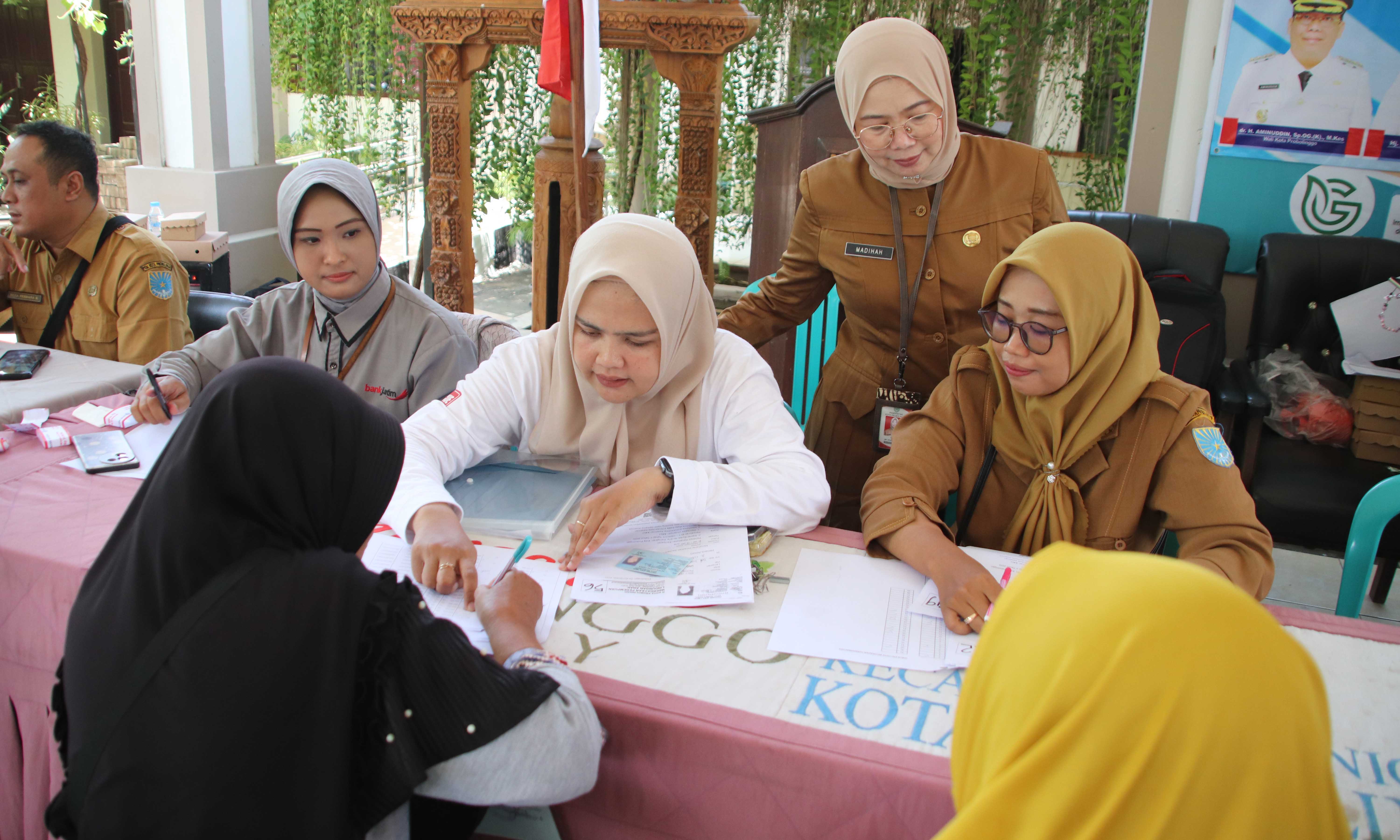 KANIGARAN: Kepala Dinsos PPPA Kota Probolinggo Madihah, SKM. terjun langsung ke lokasi penyaluran untuk memastikan BLT-DBHCHT Tahap II Tahun 2025 berlangsung lancar.