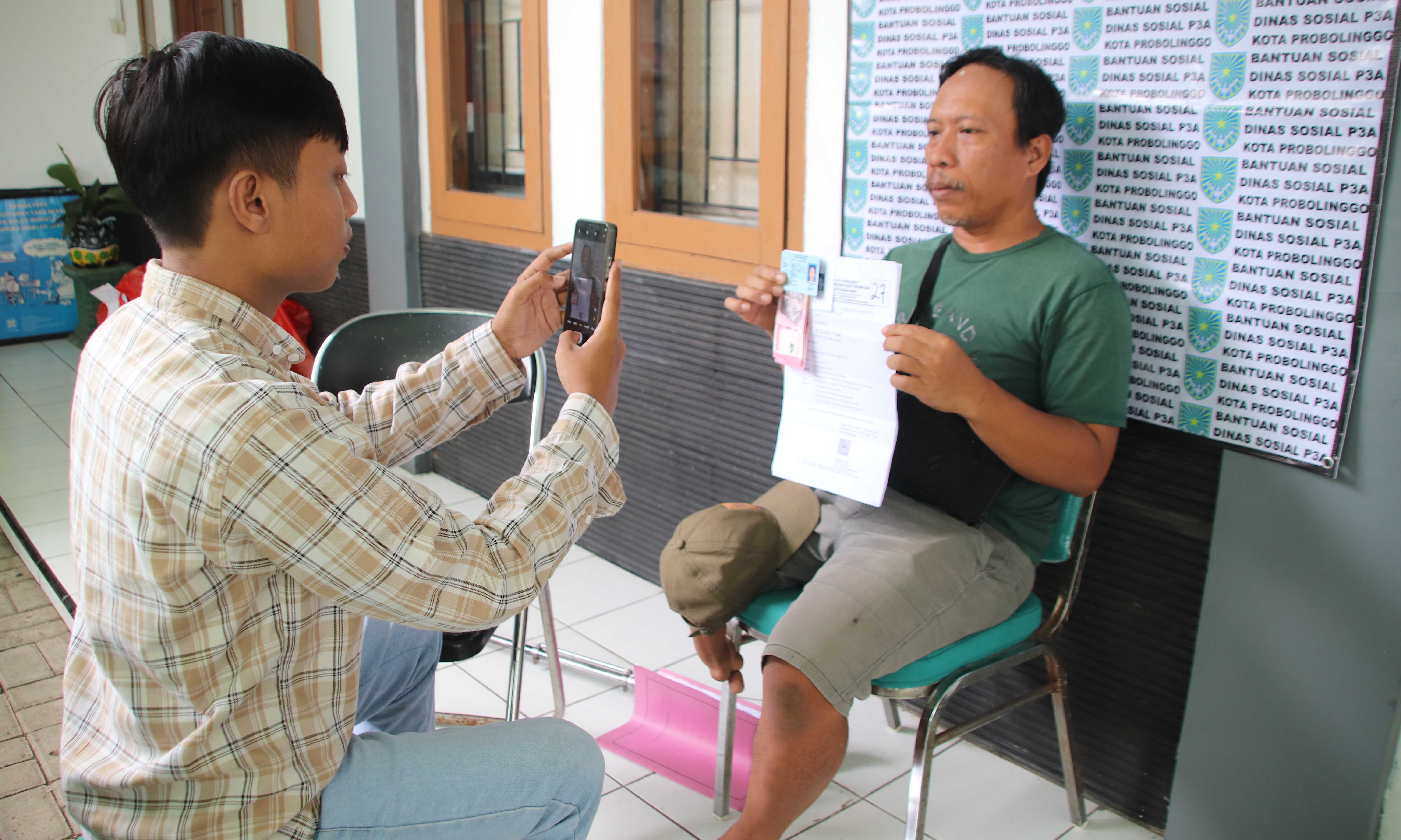 HANTARAN: Salah satu KPM disabilitas wilayah Kedopok semringah tetap mendapatkan BLT-DBHCHT yang diantarkan pegawai Dinsos ke rumahnya, Kamis (4/12).