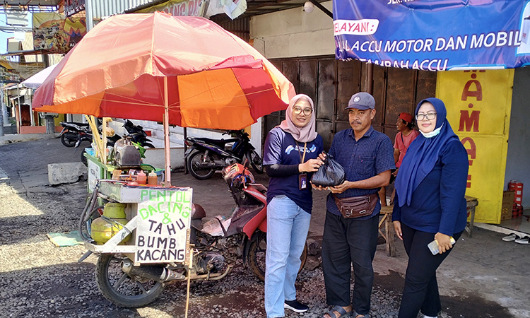 PEDULI SESAMA: Kepala Unit BRI Banyuanyar Egsi Mei Hapsari (kiri) memberikan paket sembako pada pedagang sekitar BRI Unit Banyuanyar sebagai wujud kepedulian sesama.