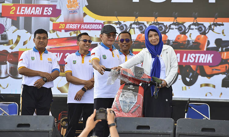 4.	PEMENANG: Salah satu peserta fun walk yang mendapatkan hadiah undian sepeda listrik di acara peringatan Hakordia 2025.