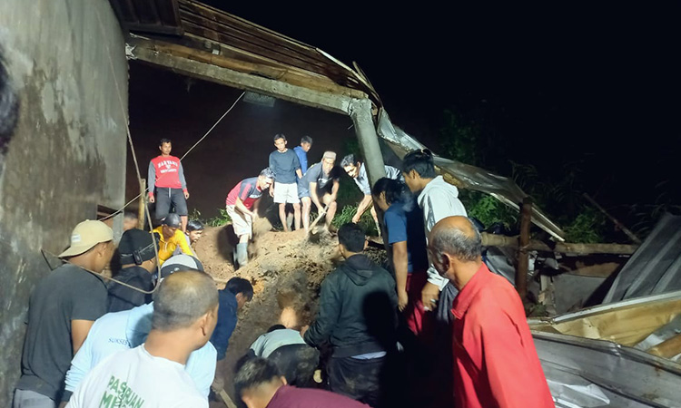 EVAKUASI: Warga membantu petugas mengevakuasi korban dan sapinya yang tertimbun material longsor.