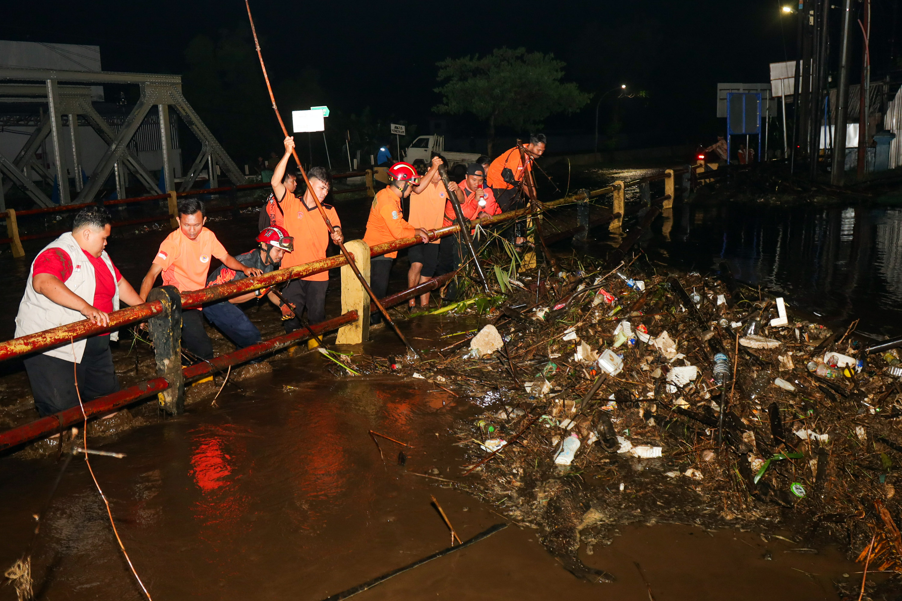 Petugas BPBD mengambil tumpukan sampah yang nyangkut di jembatan Bok Wedi, Kota Pasuruan.