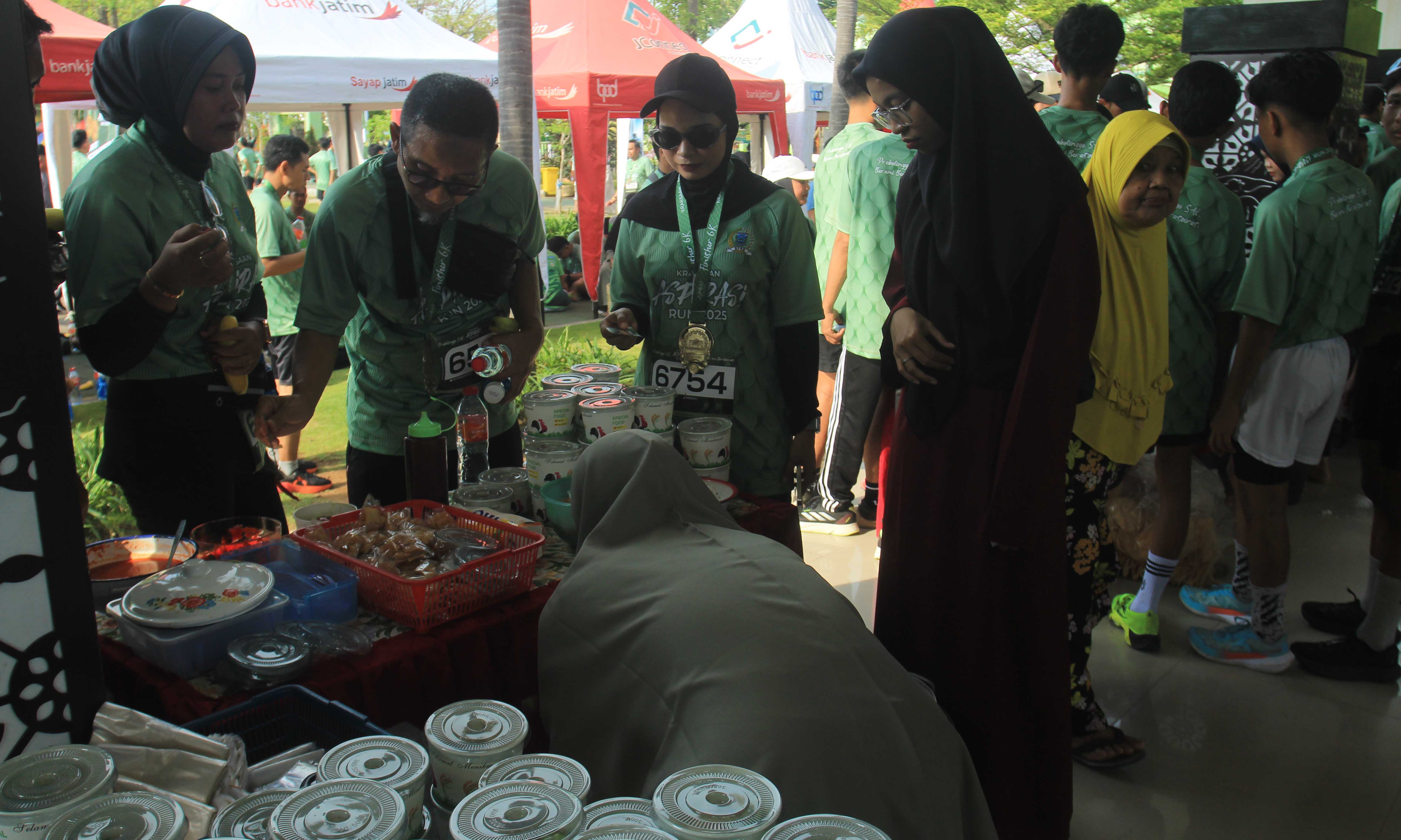 PEMBERDAYAAN: Para peserta Kraksaan Aspirasi Run menyerbu stan UMKM yang menyediakan sejumlah menu makan. Peserta cukup menyerahkan kupon makan untuk ditukar.