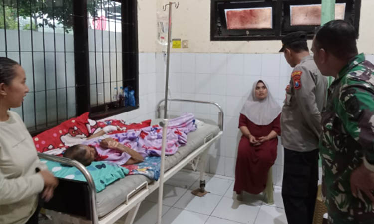 TERLUKA: Taniman yang terbaring di tempat tidur mendapat perawatan di Puskesmas Ranugedang, setelah Selasa (8/12) dinihari dibacok perampok.