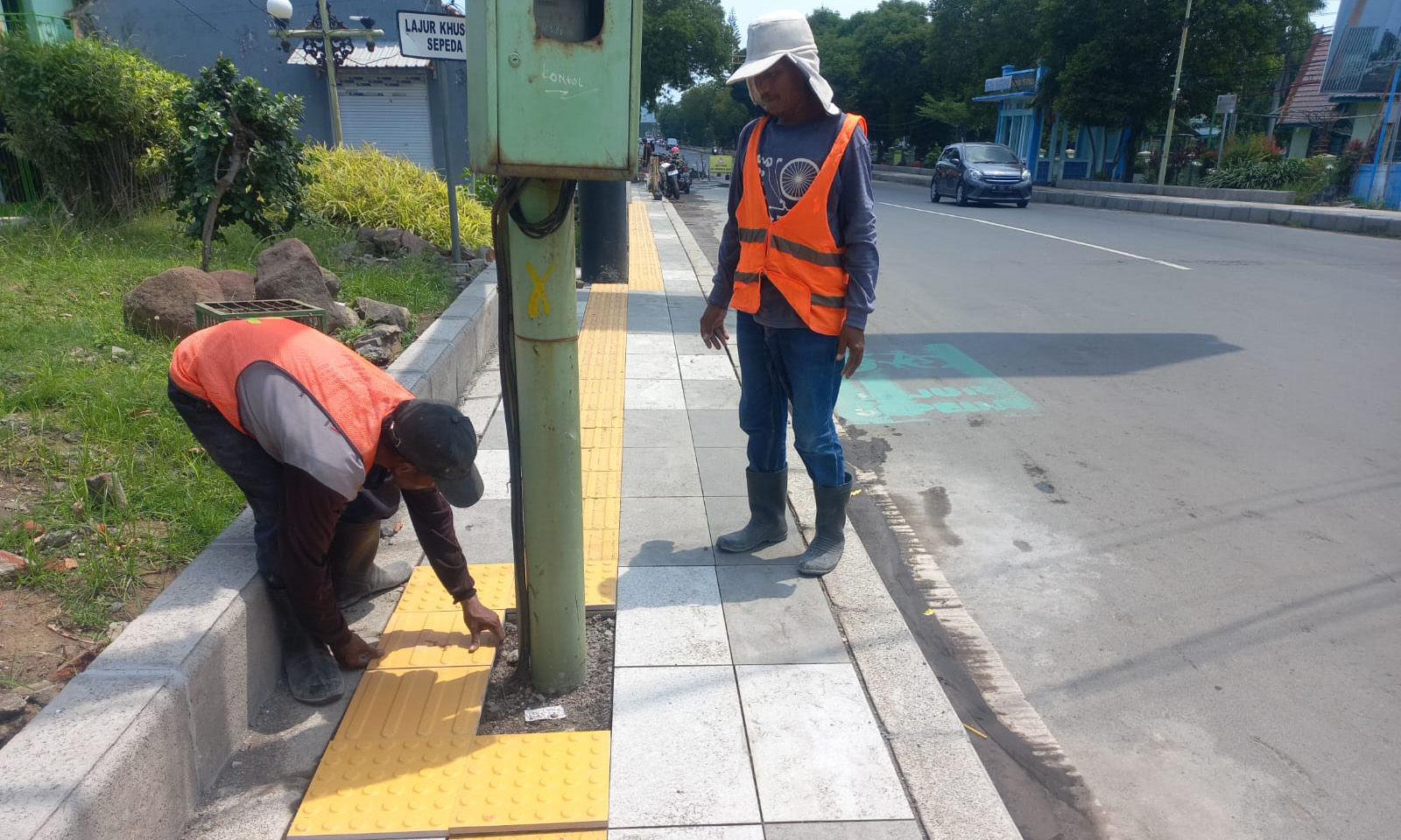DIPERBAIKI: Mandor dan tukang proyek memperbaiki blind board di Jalan Soekarno Hatta, Kota Probolinggo, Minggu (7/12).
