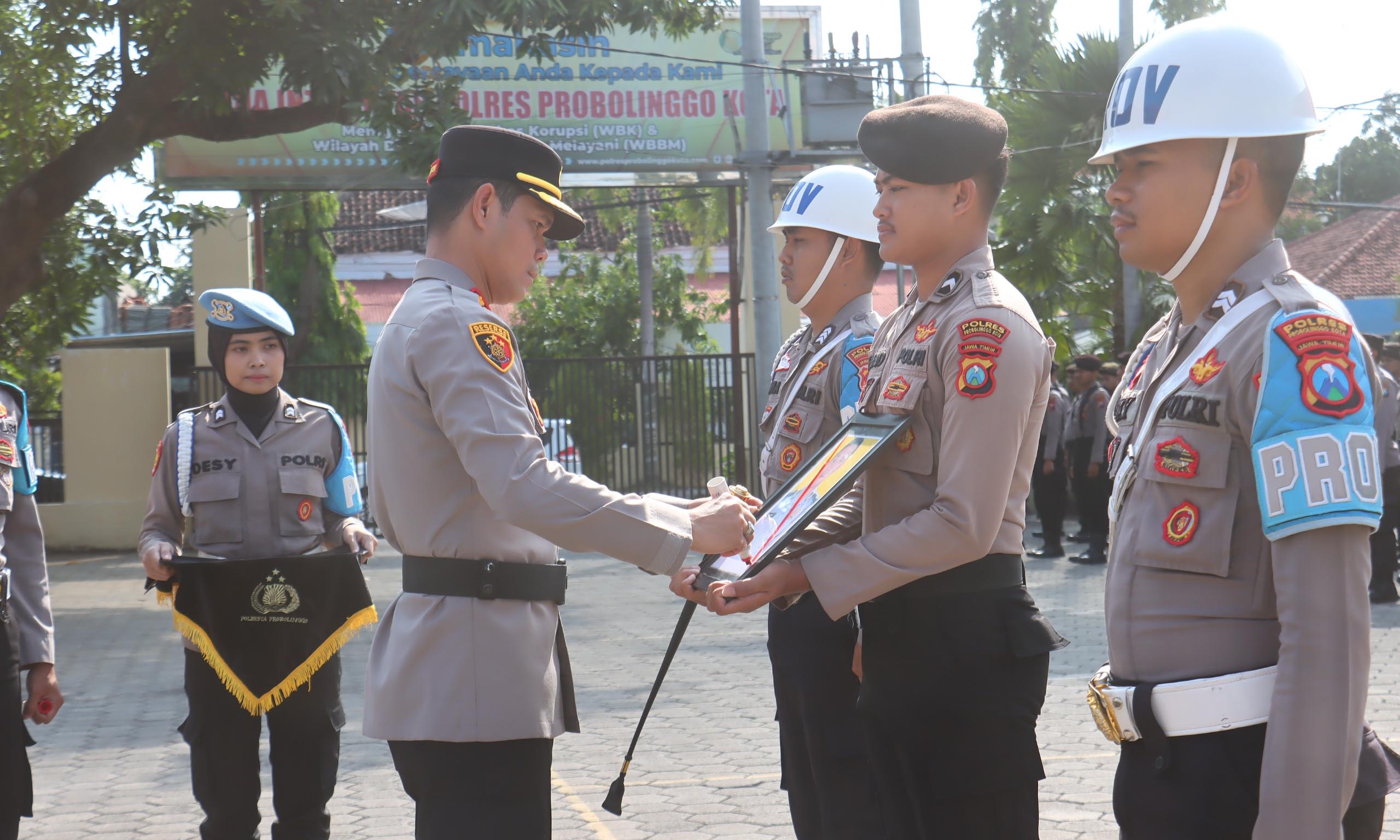 UPACARA: Kapolres Probolinggo Kota AKBP Rico Yumasri mencoret foto Bripka M sebagai penanda PTDH atasnya, Senin (8/12).