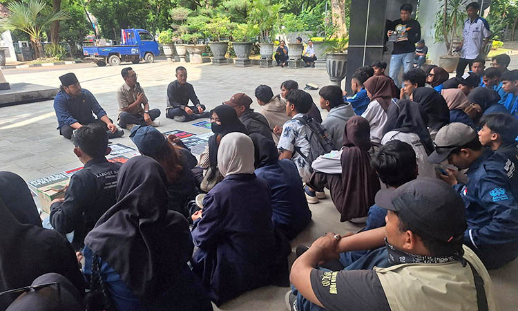 NGEMPER: Puluhan mahasiswa saat menyuarakan aspirasinya di DPRD Kabupaten Pasuruan. Mereka memilih ngemper di halaman dewan.