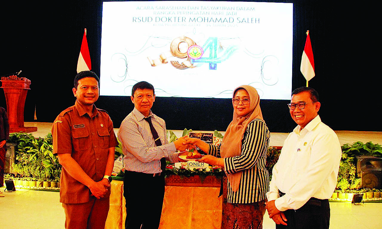 POTONG TUMPENG: Asisten Pemerintahan Pemkot Probolinggo Budiono Wirawan memperbikan potongan tumpeng pertama kepada Direktur RSUD dr. Mohamad Saleh N.H. Hidayati.