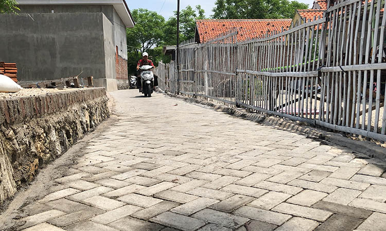 NYAMAN: Kaur Pembangunan Desa Gili Ketapang, Abdul Rosid saat melintas di ruas jalan yang telah dipaving di Desa Gili Ketapang, Kecamatan Sumberasih.