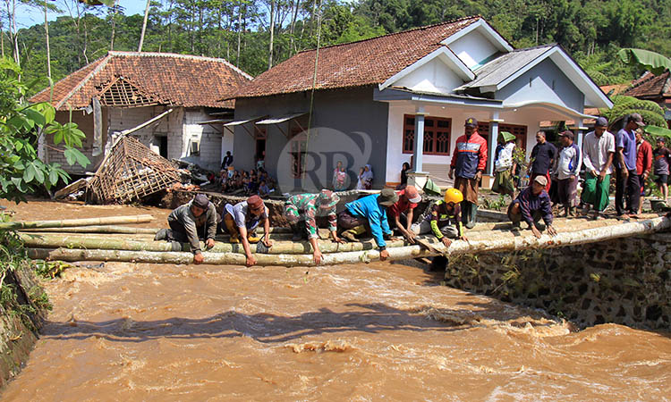 TERPUTUS: Jembatan di Dusun Kedaton, Desa Andungbiru yang terputus setelah banjir bandang menerjang, Kamis (11/12) sore.
