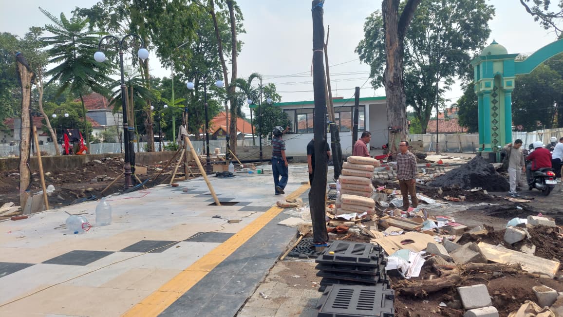 TELAT: Ketua Komisi III DPRD Kota Probolinggo, Muclas Kurniawan menunjukan progres pekerjaan revitalisasi alun-alun yang saat ini masih minus 25 persen.