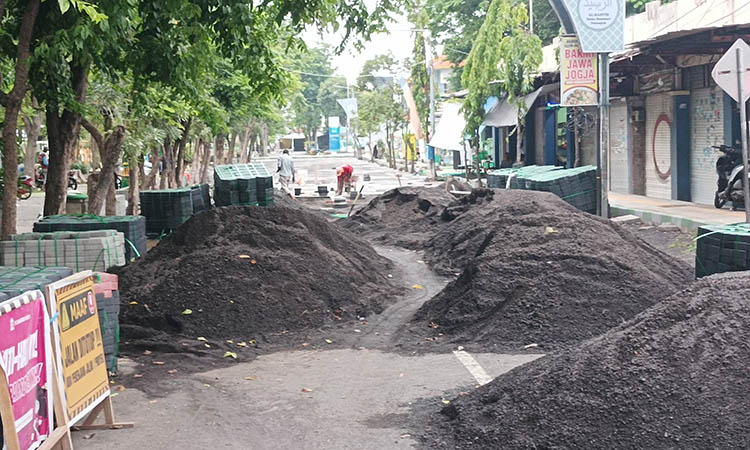 TERKENDALA CUACA: Proses pemasangan paving di wilayah sisi Timur Alun-alun Kraksan.