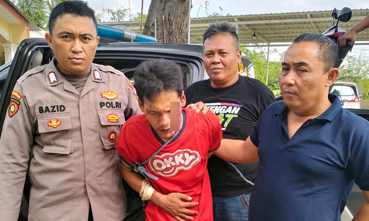 DIAMANKAN: Deni Santoso (baju merah) saat diamankan petugas Polsek Purwosari.