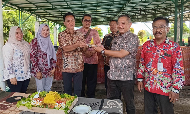 POTONG TUMPENG: Kepala Desa Brani Wetan Ir. Sujoko (kiri) menyerahkan potongan tumpeng kepada Kabid Pemberdayaan Masyarakat dan Potensi Lembaga Desa Dinas PMD Kabu