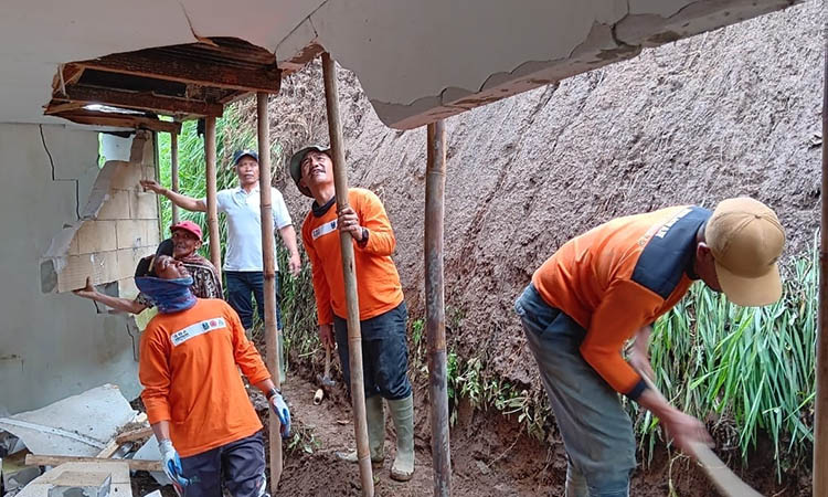 BERSIHKAN: Warga bersama Babinsa, Bhabinkamtibmas dan Pemdes Desa Ngadirejo, Kecamatan Tutur saat melakukan pembersihan material longsor yang menimpa tiga rumah warga.