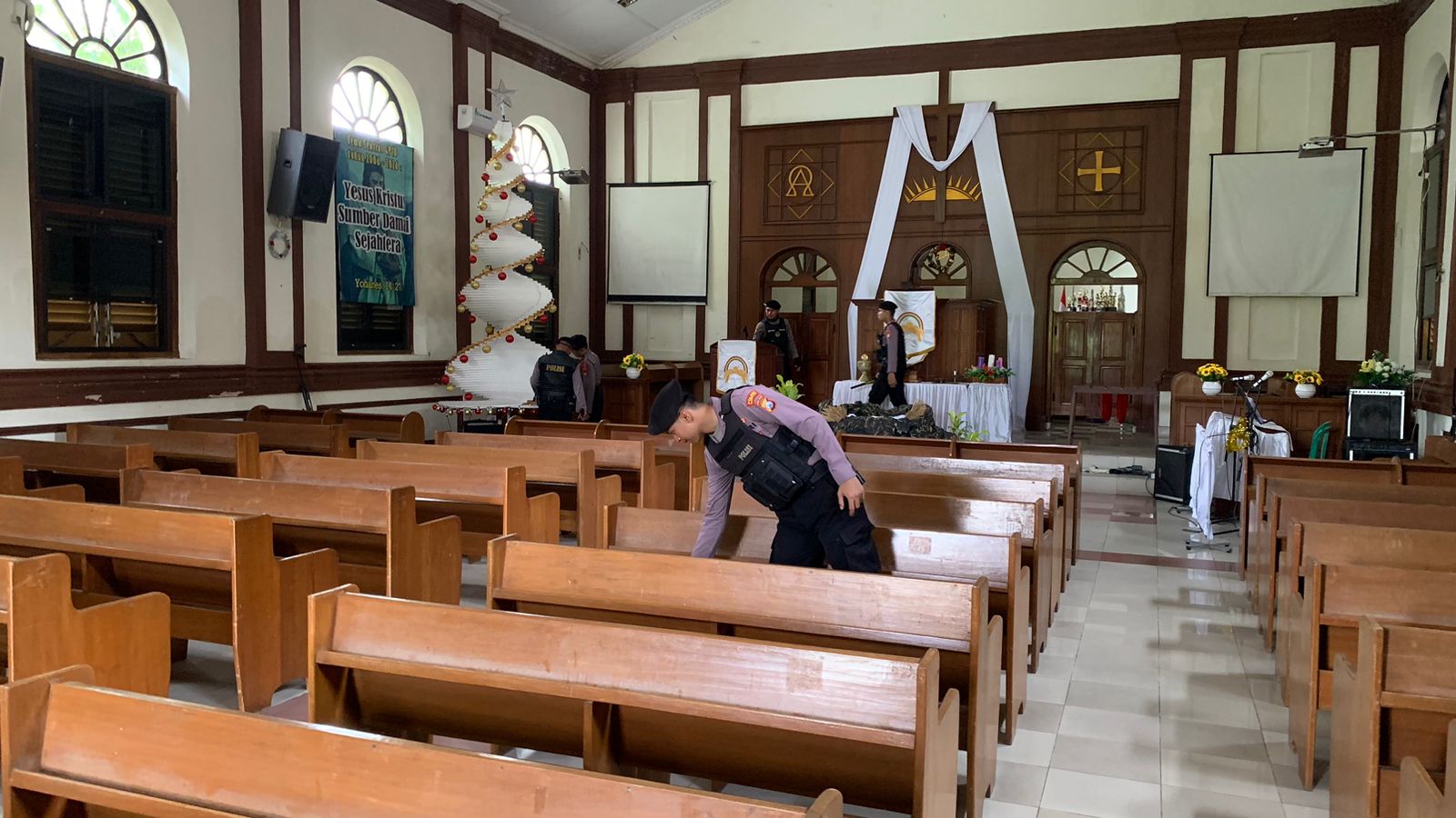 Petugas Polres Pasuruan Kota saat melakukan sterilisasi gereja jelang malam Natal.