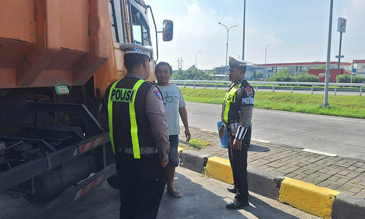SOSIALISASI: Personel Satlantas Polres Pasuruan Kota memberikan imbauan kepada sopir truk agar tak mengangkut