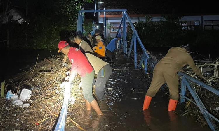 MELUAP: Aliran Sungai Kedunggaleng meluap hingga ke jembatan dan Jalan Daendels, Kecamatan Dringu, Kabupaten Probolinggo, Selasa (23/12) malam.