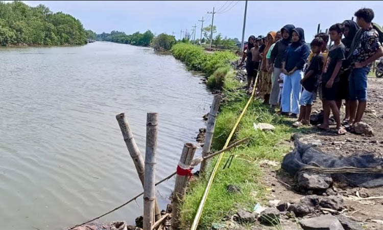 TANPA IDENTITAS: Warga berkumpul di muara sungai Desa Penambangan, Kecamatan Pajarakan untuk melihat sesosok mayat yang ditemukan Kamis (25/12) siang.