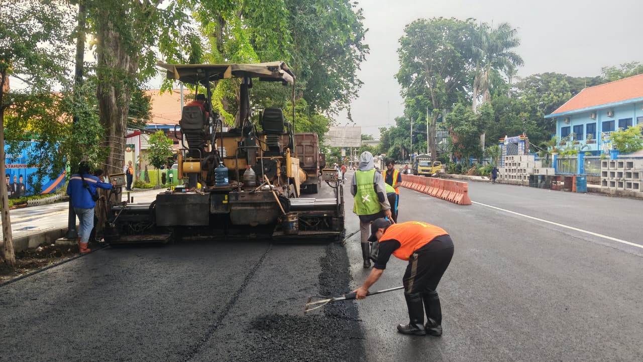 BELUM SELESAI: Pekerja proyek preservasi jalan nasional sedang mengaspal Jalan Panglima Sudirman Kota Probolinggo dan mengecor bahu jalan yang sudah diaspal.