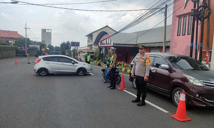 SIAGA: Petugas kepolisian saat bersiaga untuk mengawal pengendara. Meski ada kenaikan volume kendaraan, namun masih terkendali.