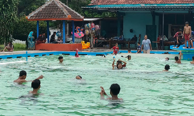 LIBURAN: Pengunjung menikmati kolam renang Jabung Tirta, Paiton. Libur panjang ini, wisata air tersebut masih lesu dan diprediksi bakal membeludak saat momen tahun baru.