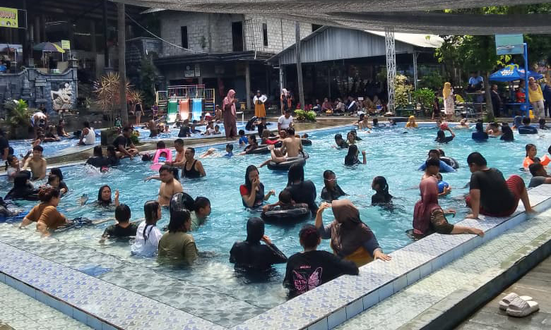 LEPAS PENAT: Sejumlah wisatawan berlibur di salah satu tempat wisata pemandian di Kecamatan Pandaan, Kabupaten Pasuruan, Minggu (28/12).