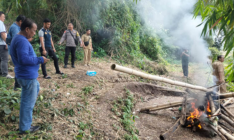 DIBAKAR: Petugas kepolisian saat membakar peralatan judi sabung ayam di Mendaalan, Desa Durensewu, Kecamatan Pandaan. Tak ada tersangka yang diamankan, lantaran saat didatangi kondisinya sudah sepi.