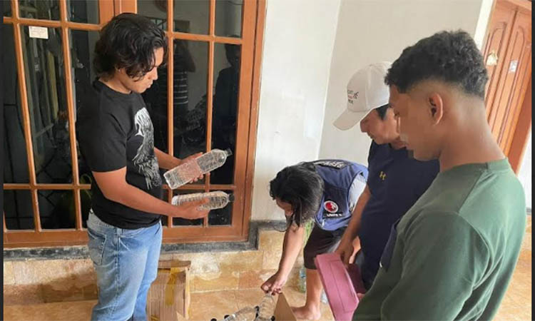KHOMER: Petugas saat mengamankan arak di rumah MH di Dusun Karanganyar, Desa Cukurgondang, Grati.