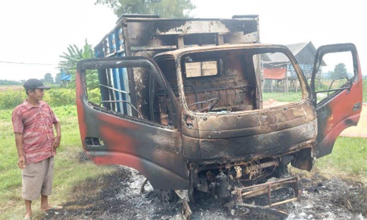 BARANG BUKTI: Warga yang penasaran berdatangan melihat kondisi bangkai truk yang dibakar masa karena ketahuan digunakan untuk mengangkut sapi hasil curian.