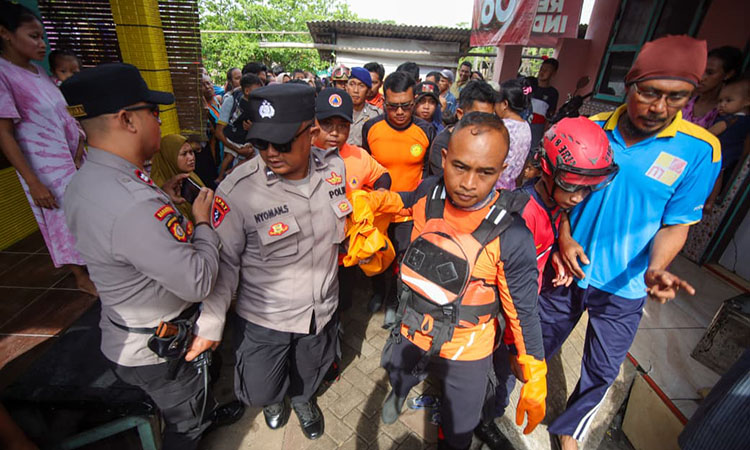 NAHAS: Petugas saat mengevakuasi jenazah balita El yang ditemukan meninggal di bibir pantai Panggungrejo, Kota Pasuruan (4/1).