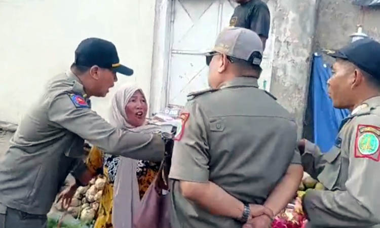 DITERTIBKAN: Petugas Satpol PP Kota Pasuruan saat melakukan penertiban lapak PKL yang berada di trotoar. Upaya itu, ternyata mendapat perlawanan dari pedagang.