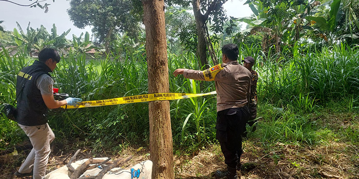 POLICE LINE: Petugas saat memasang police line di lokasi tempat korban ditemukan gantung diri.