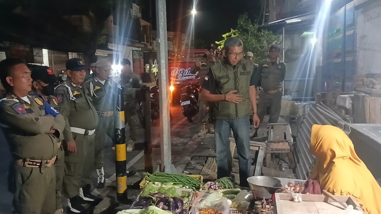 PENERTIBAN: Satpol PP Kota Probolinggo menertibkan pedagang yang berjualan di trotoar sekitar Pasar Baru Kota Probolinggo, Selasa (6/1) malam.